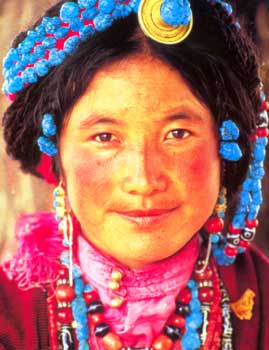 Donna tibetana riccamente ornata di coralli e turchesi.